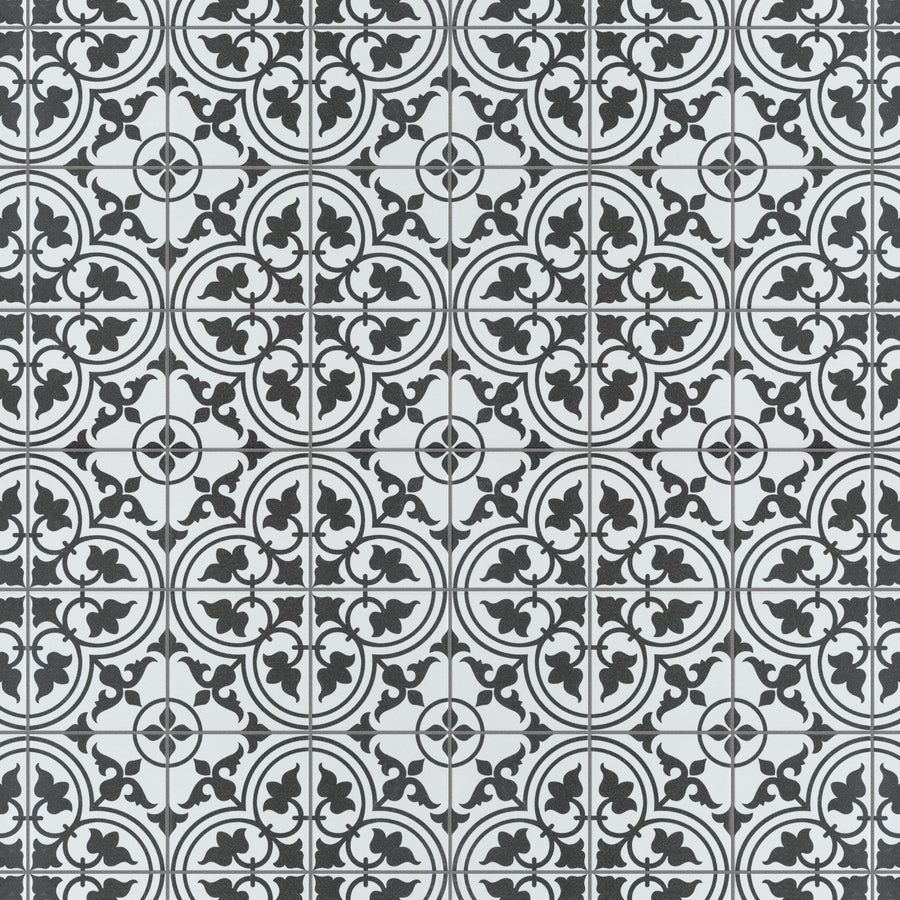 Black and white patterned tiles featuring repeating circular floral and geometric designs, creating a symmetrical and intricate mosaic effect across the surface.