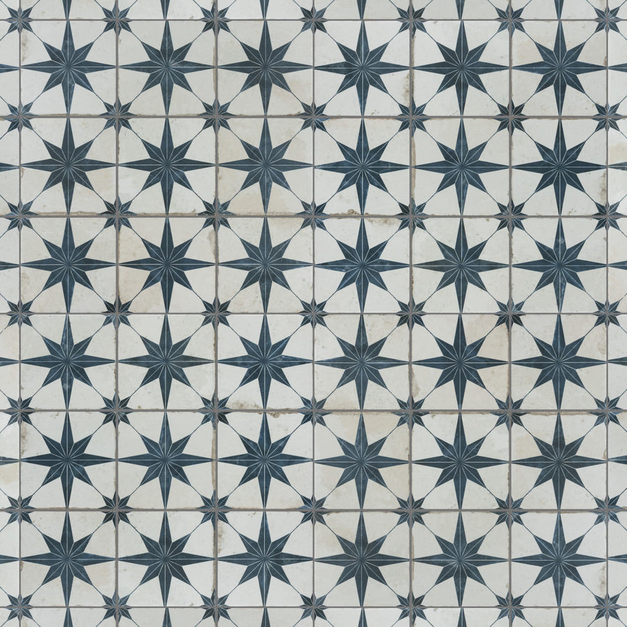 A tiled surface with a repeating pattern of dark blue eight-pointed stars on a white background, separated by thin lines, forming a geometric and symmetrical design.