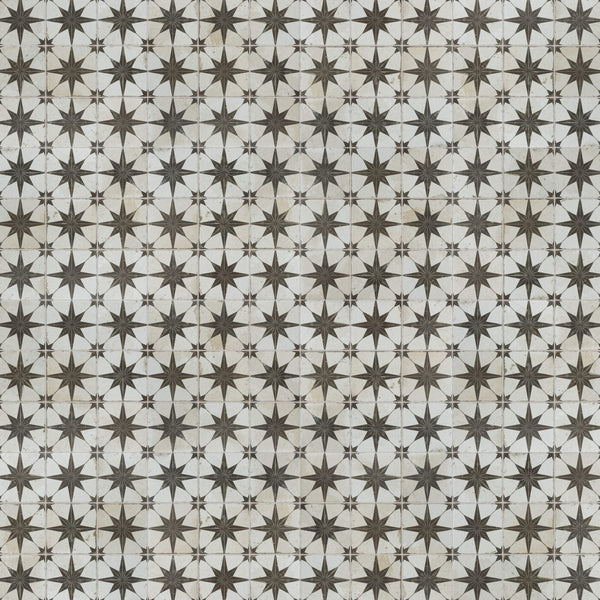 A repeating geometric pattern of black and gray eight-pointed stars on a light background, creating a tiled, symmetrical design.