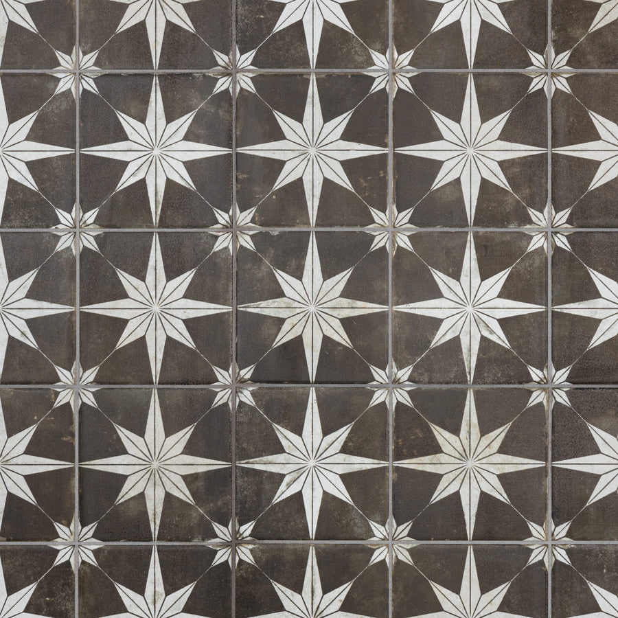 A repeating pattern of white eight-pointed stars on dark brown square tiles, creating a geometric and symmetrical design.