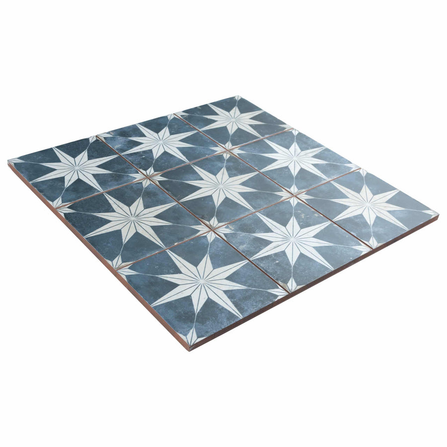 A square arrangement of blue tiles featuring a repeating white starburst pattern, each tile aligned to create a seamless geometric design.