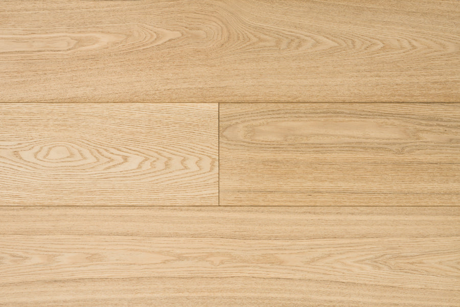 Close-up of Huntington European Oak 7 1/2″ Hardwood in Bluff, showcasing visible grain patterns and natural textures. The planks, enhanced by a reactive stain, are arranged horizontally for a clean, uniform appearance.