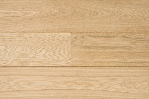 Close-up of Huntington European Oak 7 1/2″ Hardwood in Bluff, showcasing visible grain patterns and natural textures. The planks, enhanced by a reactive stain, are arranged horizontally for a clean, uniform appearance.