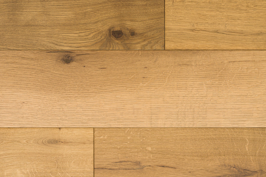 Huntington European Oak 7 1/2″ Hardwood in the color Ridge showcases light brown planks with natural grain and knot patterns, arranged in a staggered layout. This flooring features a subtle reactive stain that enhances its authentic character.