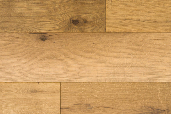 Huntington European Oak 7 1/2″ Hardwood in the color Ridge showcases light brown planks with natural grain and knot patterns, arranged in a staggered layout. This flooring features a subtle reactive stain that enhances its authentic character.