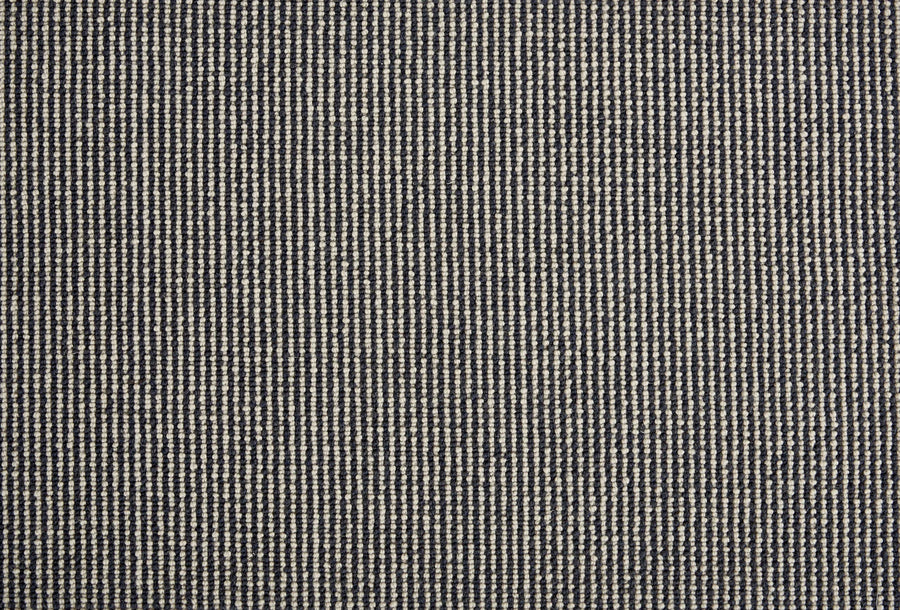 Close-up of Harper Berber Carpet in Ink, featuring a small, repeating black and white woven pattern. The grid-like texture delivers a subtle, neutral look with timeless style and everyday durability.