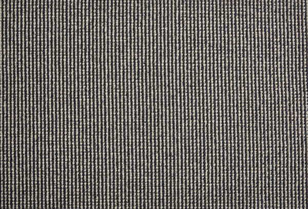 Close-up of Harper Berber Carpet in Ink, featuring a small, repeating black and white woven pattern. The grid-like texture delivers a subtle, neutral look with timeless style and everyday durability.