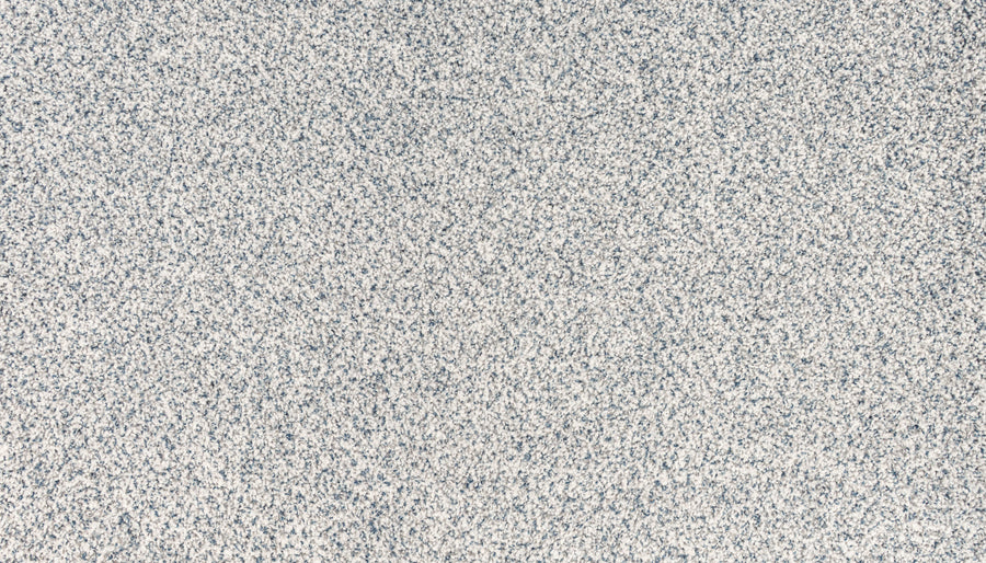 Close-up of the Brocade color of Innovative Comfort I Pet Friendly Carpet, showing a textured surface with small, densely packed gray and white speckled dots for a luxurious, grainy look that's also great for pets.