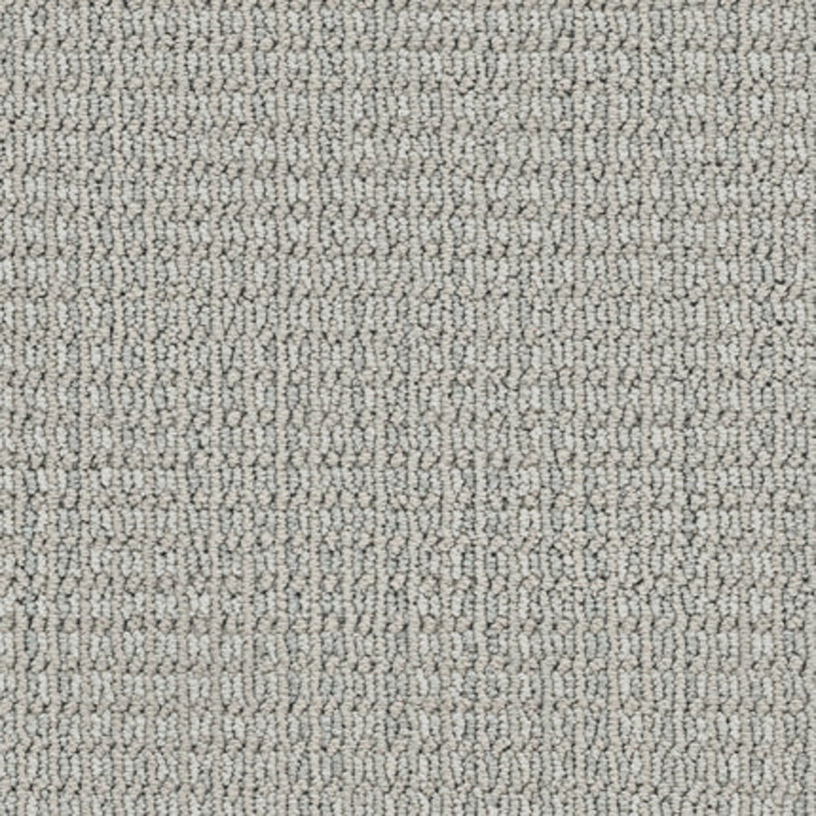 Close-up of Haven Berber Carpet in Intuitive, featuring a light gray color and looped pile with a subtle linear pattern. The tightly woven texture offers style and durability for any space.
