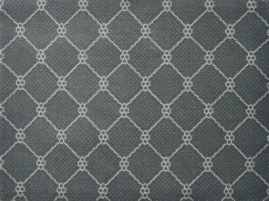 Lake Boden Berber Carpet in Iron features a repeating white-outlined diamond pattern with small floral clusters, offering a stylish and durable flooring option ideal for modern homes.