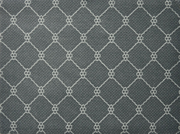 Lake Boden Berber Carpet in Iron features a repeating white-outlined diamond pattern with small floral clusters, offering a stylish and durable flooring option ideal for modern homes.