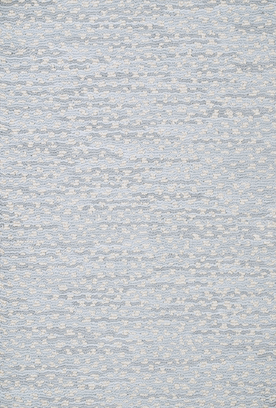 A close-up of Jag On Trend Carpet shows a woven pattern in light blue and off-white, with a subtle, irregular dotted texture that exudes luxurious elegance.