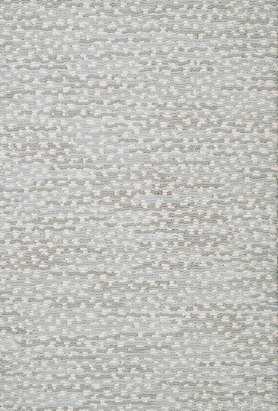 The Jag On Trend Carpet features a close-up of textured fabric in light grey and white dots, showcasing subtle, soft neutral tones for an elegant, luxurious feel.