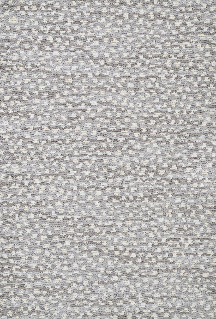 Close-up of Jag On Trend Carpet’s textured, woven fabric featuring small, irregular white and light gray shapes on a medium gray background, capturing its soft surface and luxurious elegance.