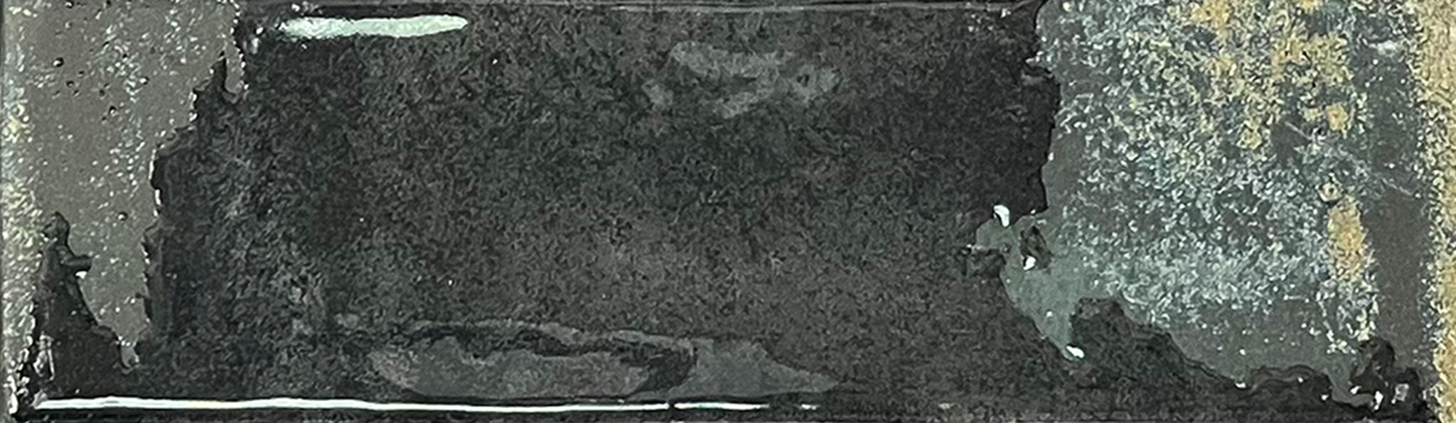 
		                            A rectangular Kinetic 2.5x9 Porcelain Subway Tile in the Fluid Force color features a dark, weathered metal appearance with a rough, uneven texture, lighter gray accents, and small spots of rust-like detailing that evoke the aged and distressed look often seen in artisanal pottery or well-worn porcelain tiles.
		                            