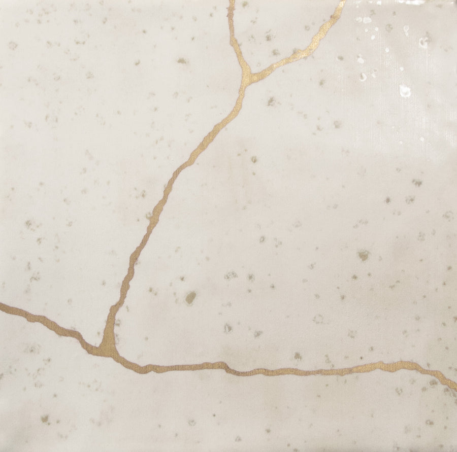 The Kintsugi 5" x 5" Ceramic Tile in ivory features golden cracks inspired by Japanese Kintsugi, ideal for use as an artistic backsplash or accent wall tile.