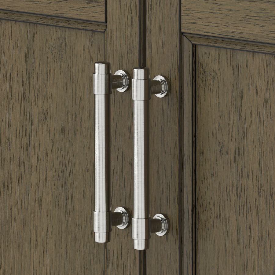 Two brushed metal handles are mounted vertically on the doors of a wooden cabinet with a dark, textured finish. The cabinet doors meet in the center, and the handles are parallel to each other.