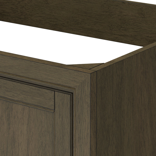 A close-up of a wooden cabinet corner with a dark brown finish, showing part of the side panel, front frame, and raised panel door. The top of the cabinet is open without a countertop.