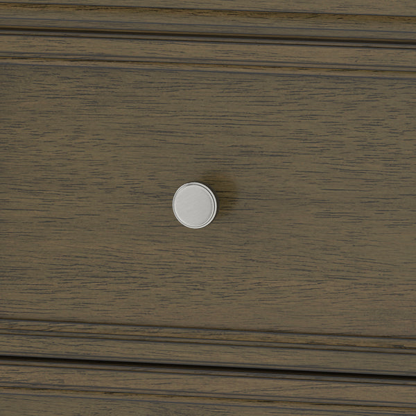 Close-up of a wooden drawer with a round, silver-colored knob in the center. The wood has a dark brown finish with visible grain texture.