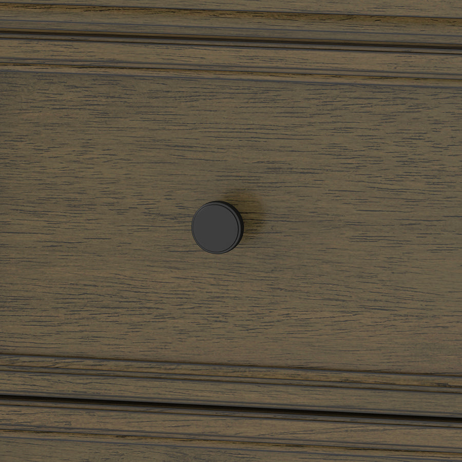 Close-up of a wooden drawer with a dark round knob handle in the center. The wood has a natural, textured grain and a brown finish.