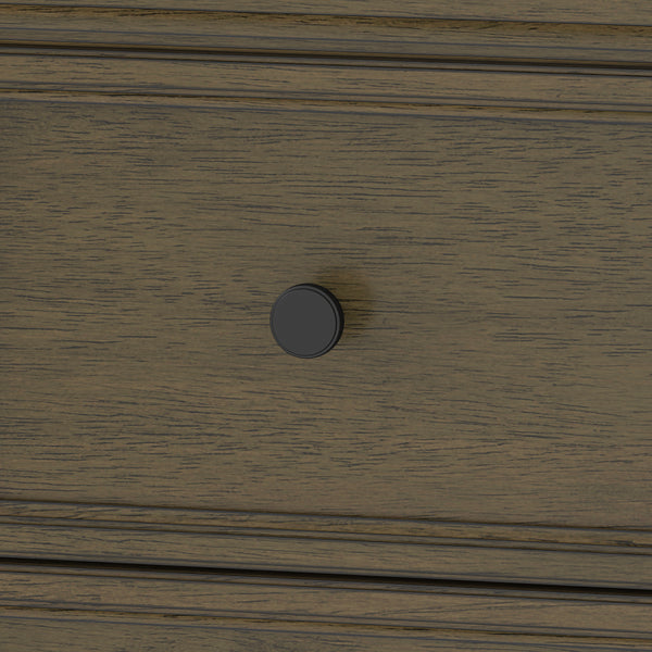 A close-up of a wooden drawer with a dark round knob handle at the center. The wood has a textured, brown finish with visible grain patterns.