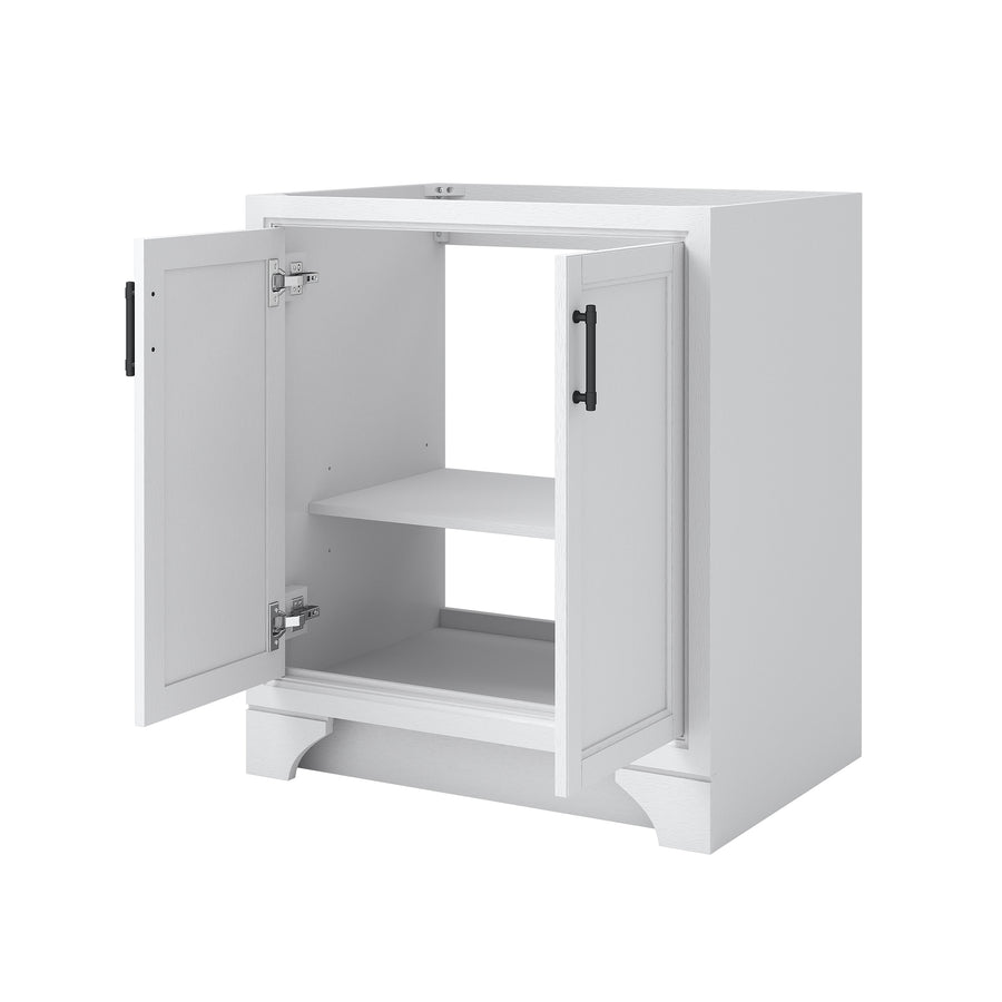A white kitchen cabinet with two doors open, revealing an interior shelf. The cabinet has black handles and stands on a short base with decorative trim.