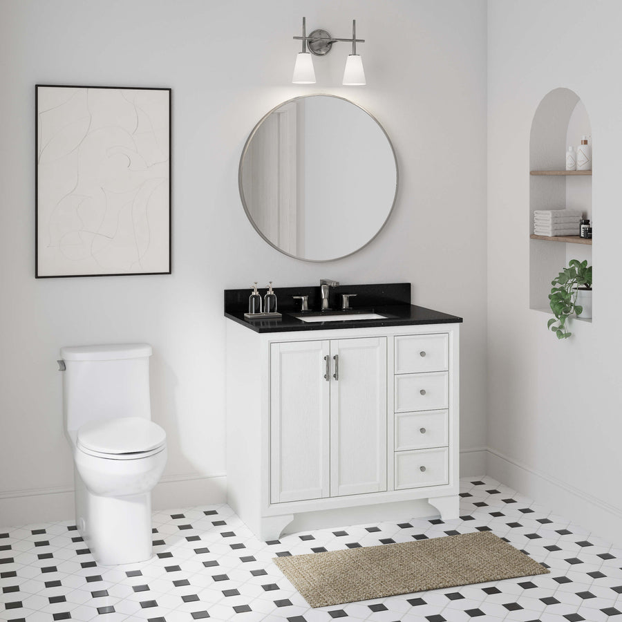 A modern bathroom with the Lanagan 36" Vanity, black countertop, round mirror, geometric tile floor, wall art, and a decor shelf. The vanity provides ample storage and delivers a chic minimalist style.
