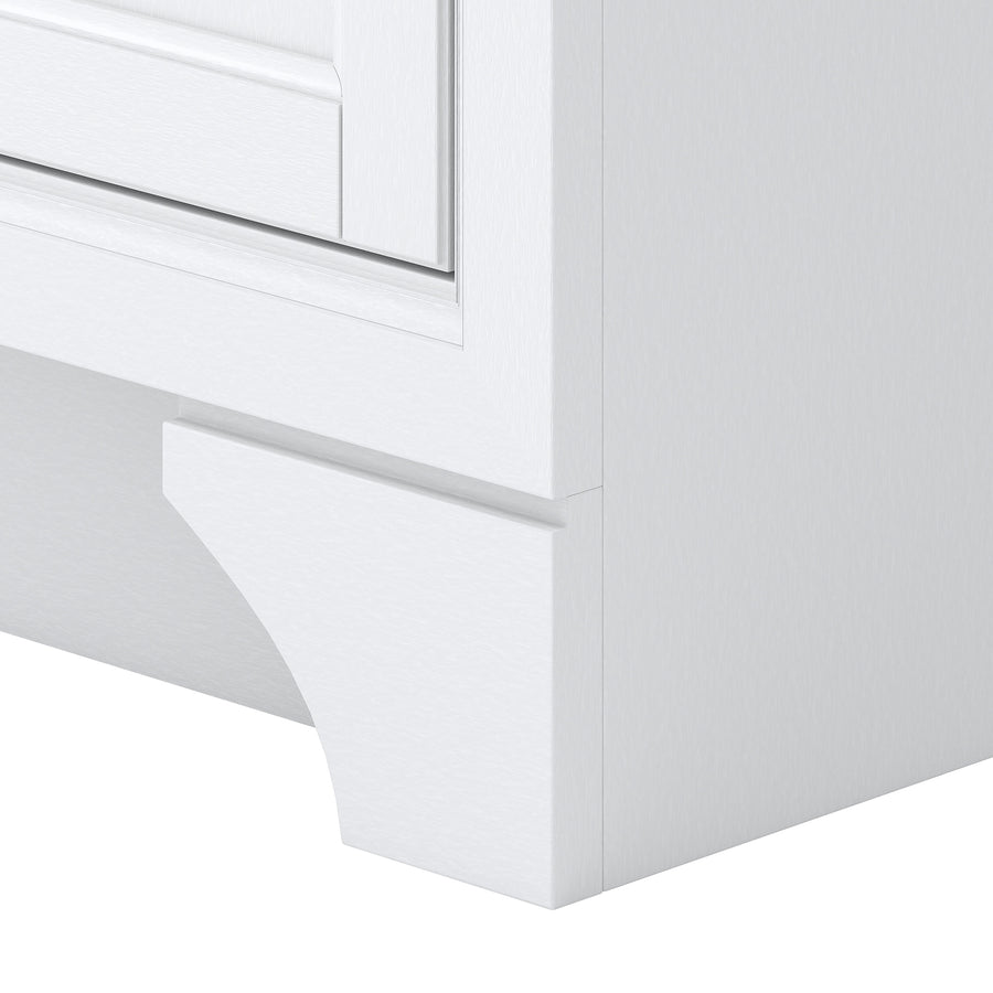 A close-up view of the bottom corner of a white cabinet, showing decorative molding with a curved detail at the base.
