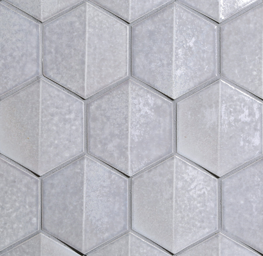 Close-up of Shinju Hex Mosaic Tile in Crest color, featuring light gray hexagons with a subtly textured, glossy finish—perfect for creating a modern kitchen backsplash.