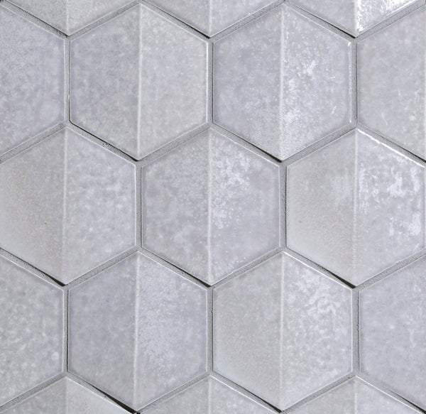 Close-up of Shinju Hex Mosaic Tile in Crest color, featuring light gray hexagons with a subtly textured, glossy finish—perfect for creating a modern kitchen backsplash.