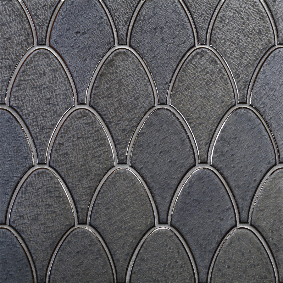 Close-up of Shinju Stingray Mosaic Tile in Cape Pearl, featuring a textured surface with overlapping, dark gray, fish scale-shaped tiles outlined by thin metallic lines for an intricate mosaic look.