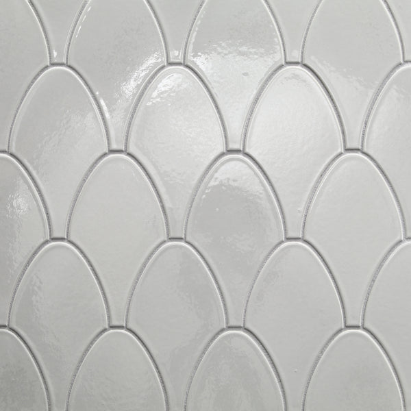 The Shinju Stringray Mosaic Tile in Kushi features glossy white tiles arranged in a repeating fish scale pattern, with subtle texture and raised edges, offering a clean, modern look and durable ceramic construction.