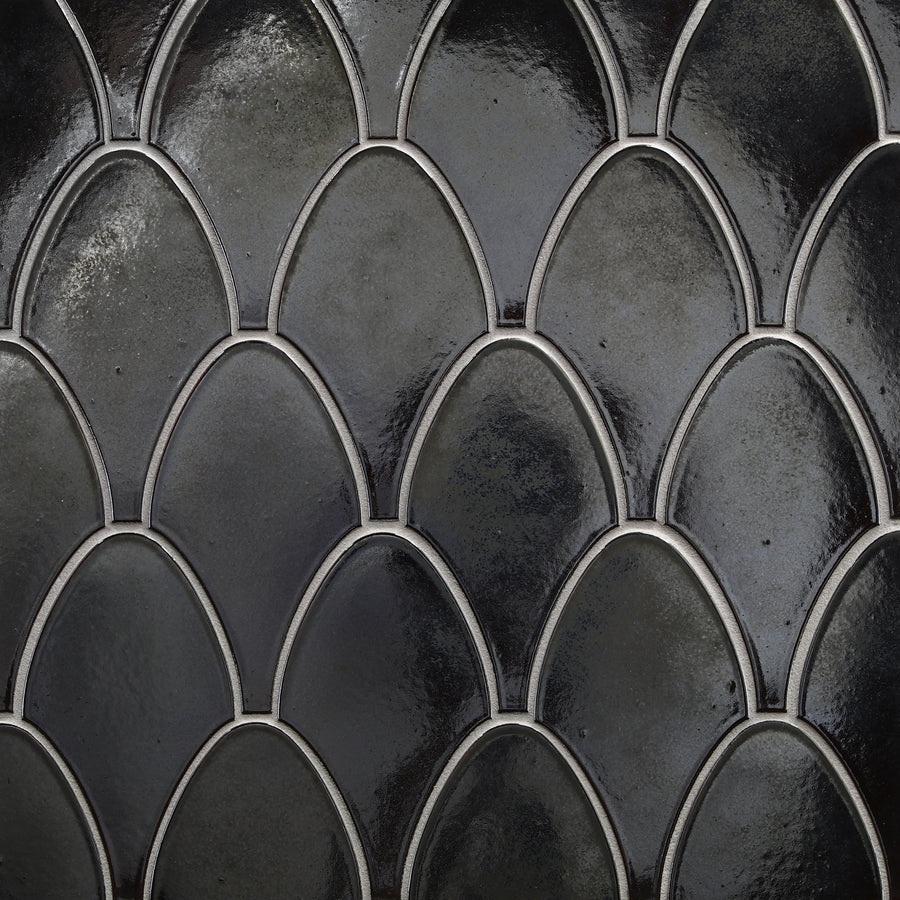 Close-up of Shinju Stringray Mosaic Tile in Olympia color, showing a dark, glossy fish scale design with smooth curved shapes, light grout outlines, and durable ceramic construction.