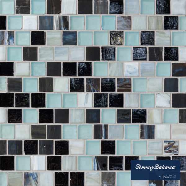 The Tommy Bahama Offset Mosaic Tile in Fujisan Mix features small square tiles in black, white, light blue, and iridescent shades—ideal for accent walls. The Tommy Bahama logo is displayed in the lower right corner.