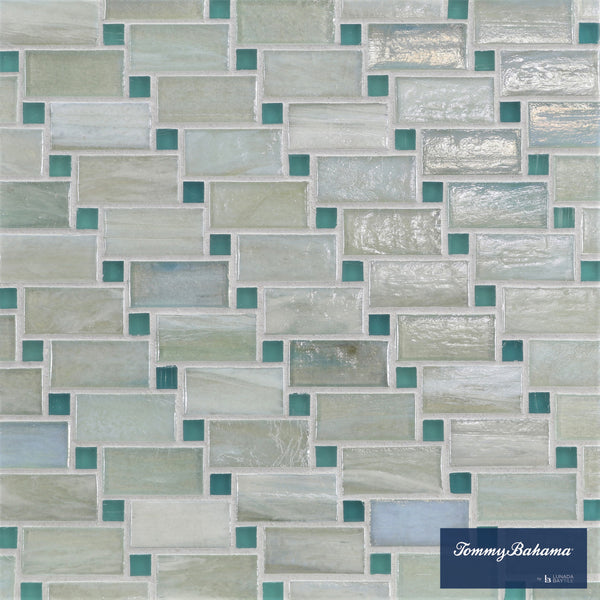 The Tommy Bahama Vineyard Mosaic Tile in San Blas Mix features rectangular ceramic tiles in white, gray, and light teal with an offset pattern—ideal for accent walls. The Tommy Bahama logo is shown in the bottom right corner.