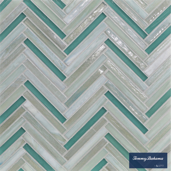 A close-up of the Tommy Bahama Zig & Zag Mosaic Tile in San Blas Mix shows a herringbone geometric pattern in soft teal, white, and light gray. The Tommy Bahama logo appears in the bottom right on a blue background.