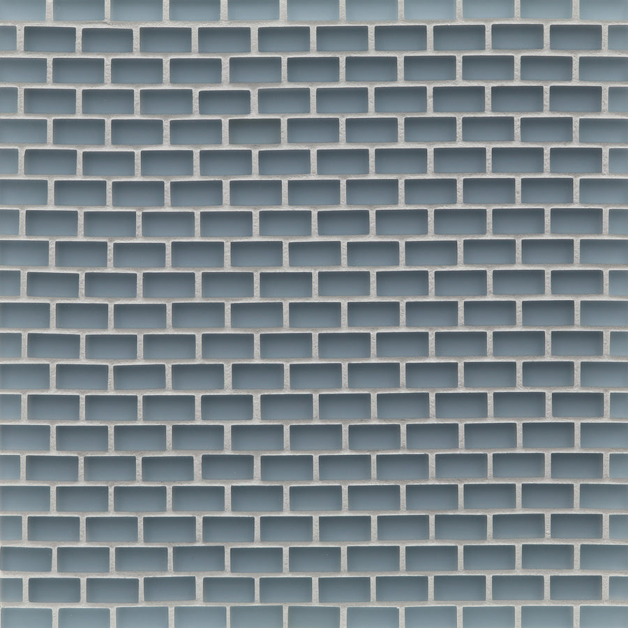 A close-up of a wall with a repeating rectangular brick pattern in light blue and white, resembling a geometric grid—perfect for backsplashes using Tomei Mini Brick Mosaic Tile in Silk.