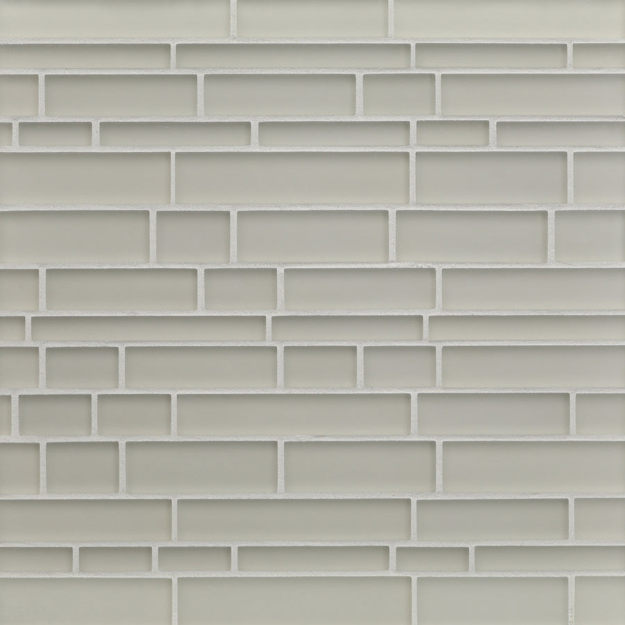 A close-up view of a wall with Tomei Falling Water Mosaic Tile in Silk, arranged in a staggered pattern with light gray ceramic tiles and white grout, creating a modern look.
