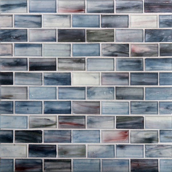 Tozen Brick Mosaic Tile in Silk features rectangular tiles arranged in a staggered pattern, showcasing a mix of blue, gray, white, and soft pink marble-like swirls for a textured ceramic look.