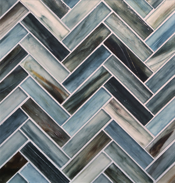 A close-up of Tozen Herringbone Mosaic Tile in the color Silk, showcasing a glossy finish and white grout that emphasizes its geometric pattern for a modern luxury look.
