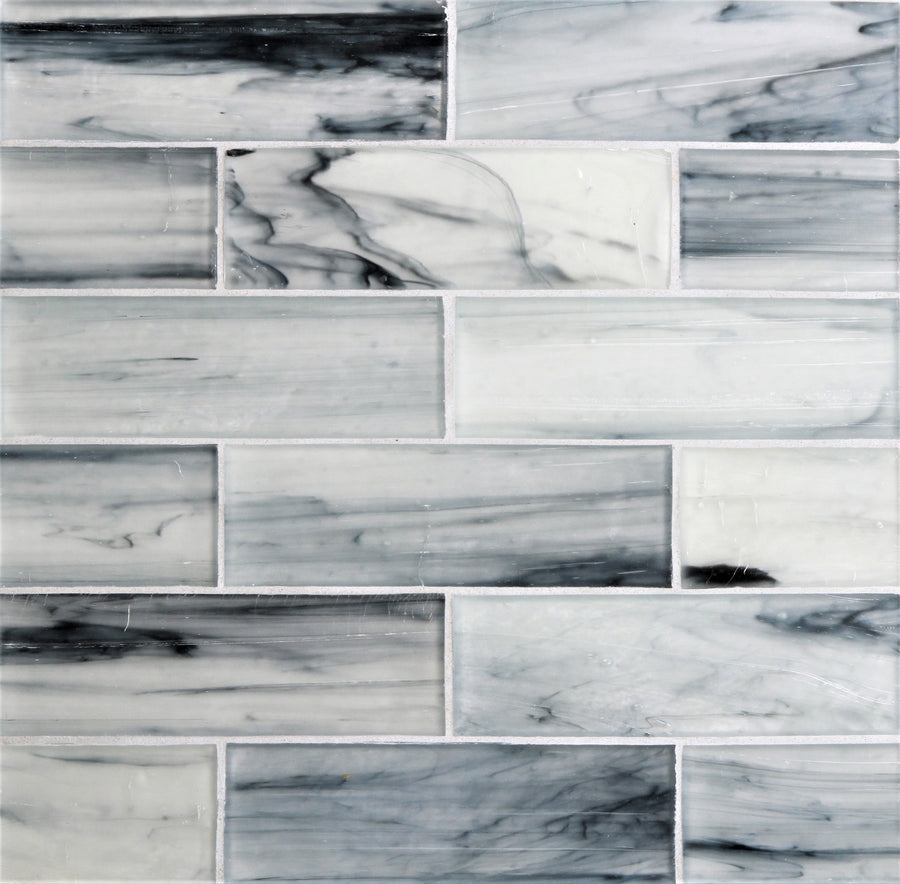 The Tozen 2" x 6" Argon Subway Tile in Silk, arranged in a staggered pattern, features subtle white, gray, and black veining for a sleek and modern look with a sophisticated finish.