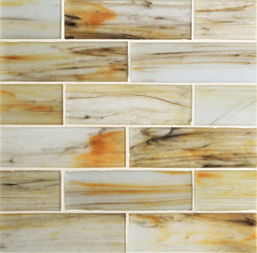 Tozen 2" x 6" Tin Subway Tile in Silk features a metallic finish with beige, amber, orange, and brown streaks and swirls, arranged in a staggered brick pattern with white grout lines.