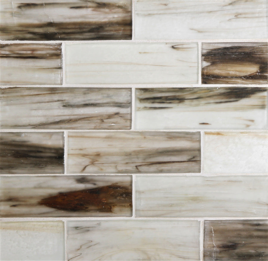The Tozen 2" x 6" Vanadium Subway Tile in Silk features a staggered layout with white, cream, and brown marbled tones that mimic natural stone, showcasing a smooth, glossy surface for a premium look.
