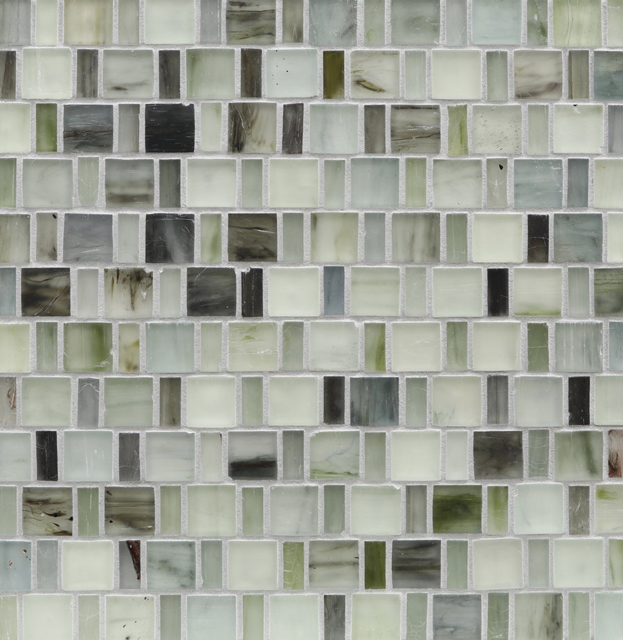 A close-up of a wall featuring Tozen Japonaise Mosaic Tile in the color Silk, arranged in a grid pattern that reflects Japanese aesthetics with white, gray, green, and cream tones.