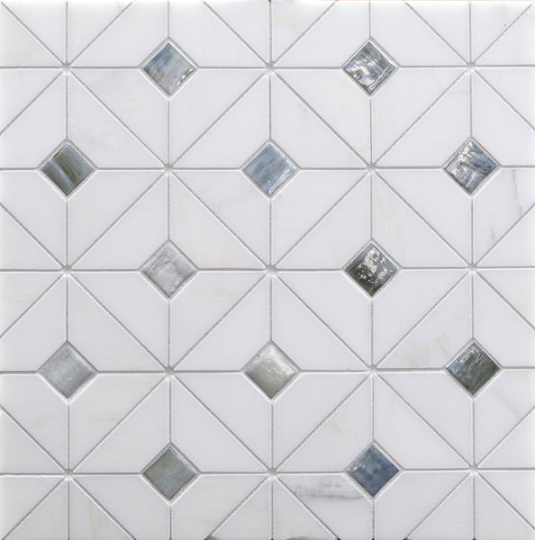 White tile wall with a geometric pattern of squares and triangles, featuring Vesuvio Quilt Mosaic Tile in Rock Garden—small reflective silver and gray diamonds—ideal for elegant backsplashes or striking accent walls.