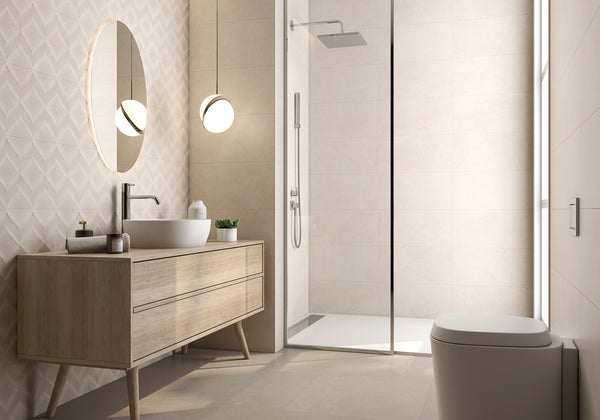 Modern bathroom with a wooden vanity, round mirror, vessel sink, pendant light, glass-enclosed shower, and wall-mounted toilet. Beige tiles cover the walls and floor, creating a clean, minimalist look.