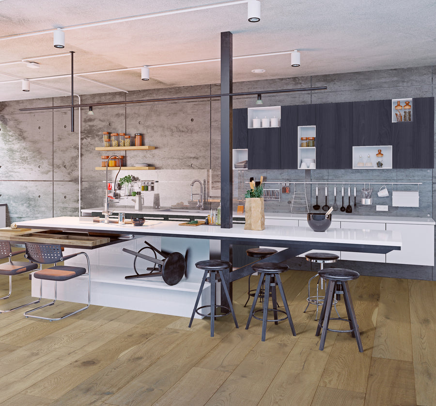 A modern kitchen with concrete walls, wooden floor, black stools at a white island, open shelving with dishes, and hanging utensils. A chair is tipped over next to the island, and the space is well-lit.