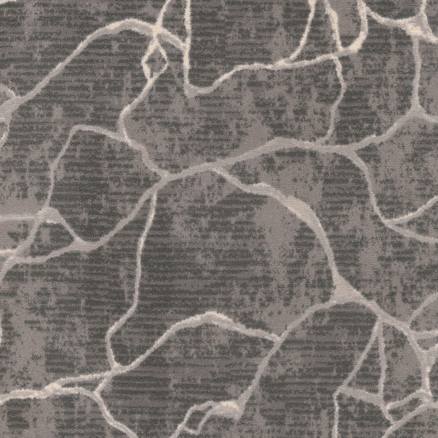 The Leading Edge On Trend Carpet features a modern, textured dark gray background accented with irregular, light-colored lines that evoke the look of natural stone with organic patterns, varying line thickness, and subtle shading.