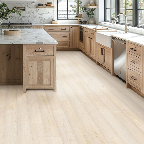 Modern kitchen with light wood cabinets, white marble countertops, stainless steel appliances, a farmhouse sink, and large windows letting in natural light. A kitchen island sits in the center with matching light wood cabinetry.