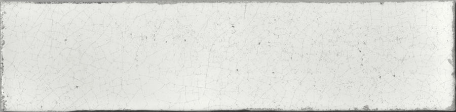 The Maiolica 3x12 Crackled Ceramic Subway Tile is a rectangular white tile with a slightly rough, crackled surface and subtle edge stains for an aged, weathered look.